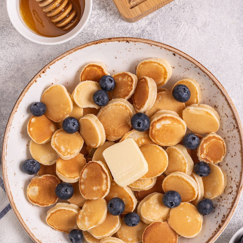 Trendy breakfast with mini pancakes and blueberries.